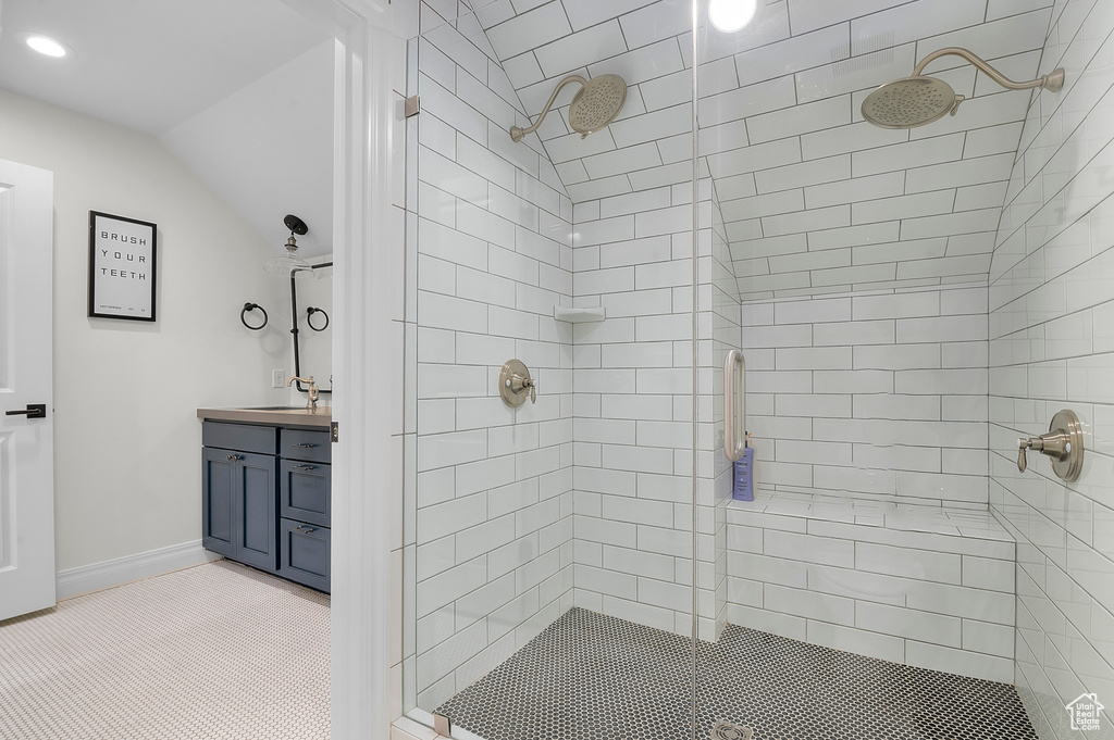 Bathroom with a shower stall, lofted ceiling, vanity, recessed lighting, and baseboards