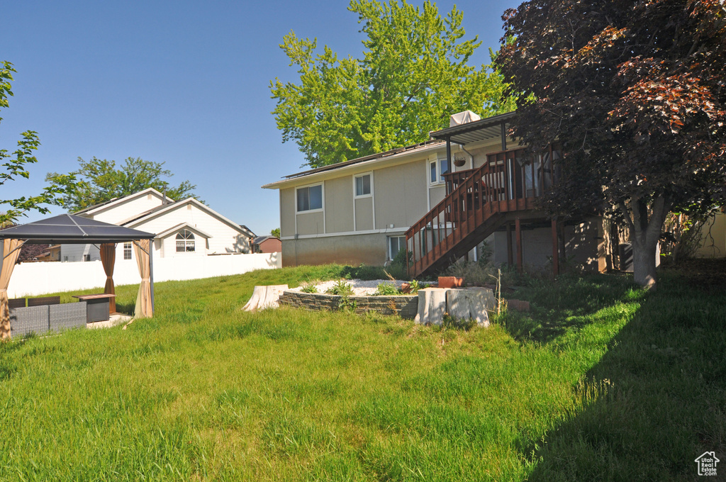 Back of property with stairway, a gazebo, and a wooden deck
