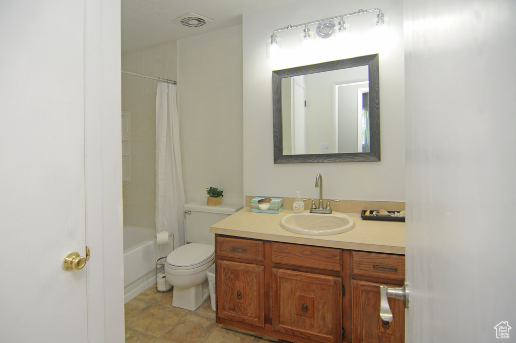 Full bath with vanity, toilet, shower / bathtub combination with curtain, and tile patterned floors