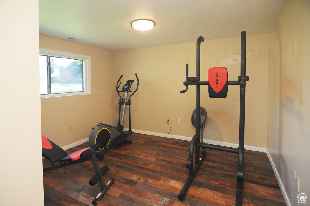Exercise room with wood-type flooring and baseboards