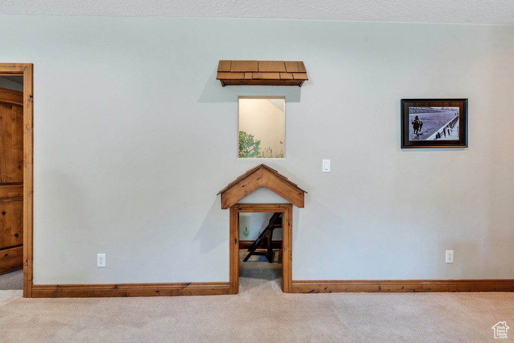 Carpeted spare room featuring baseboards