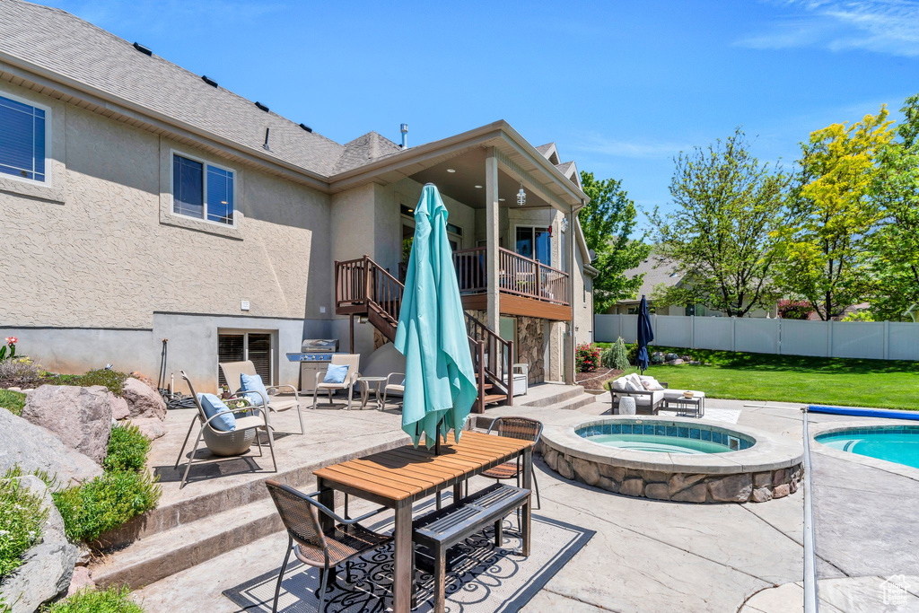 View of pool with stairs, a patio area, an in-ground hot tub, and outdoor dining space