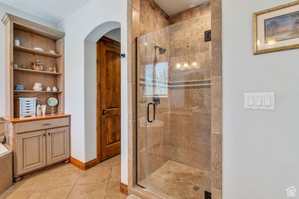 Bathroom with a stall shower and baseboards