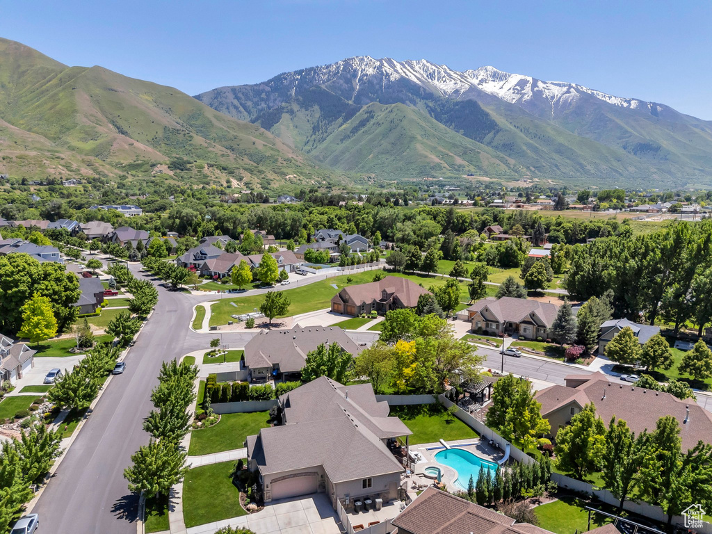 Aerial view of residential area featuring a pool area and a mountainous background