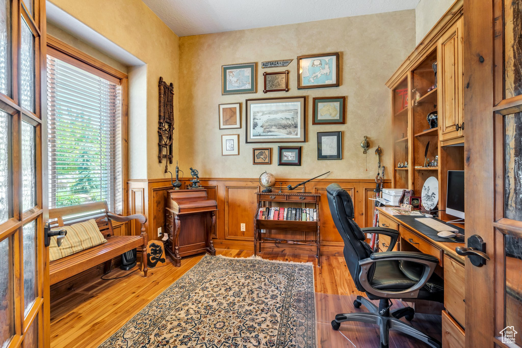 Office space featuring wood finished floors and wainscoting