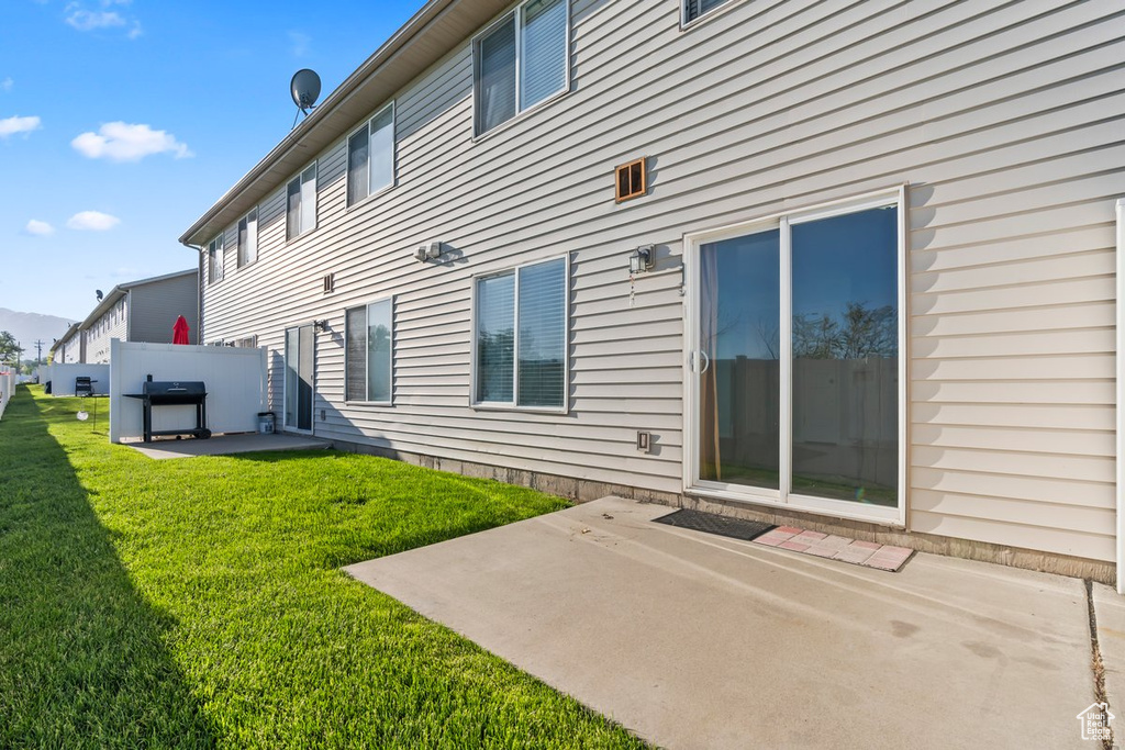 Back of property with a patio area and a lawn