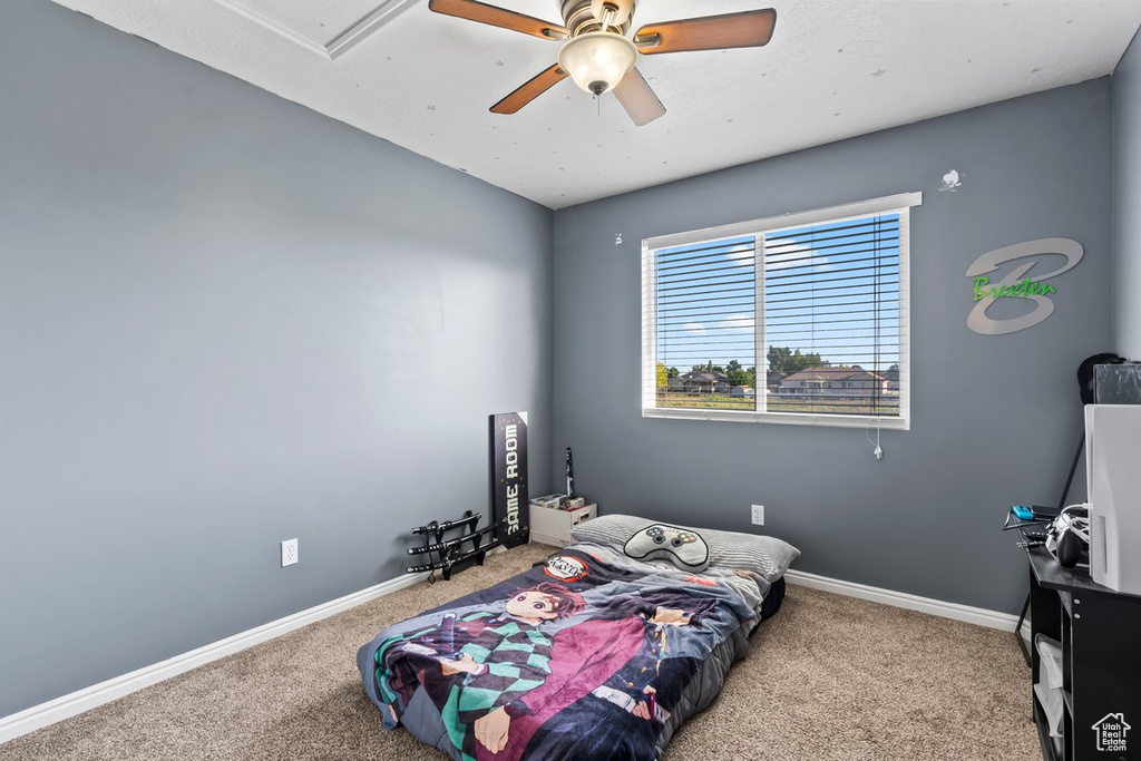 Bedroom featuring carpet floors, baseboards, and a ceiling fan