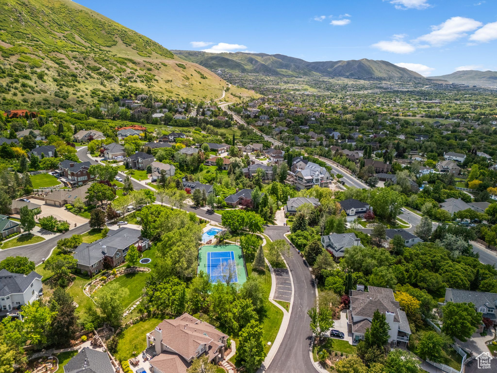Aerial view of property and surrounding area with nearby suburban area and a mountain backdrop