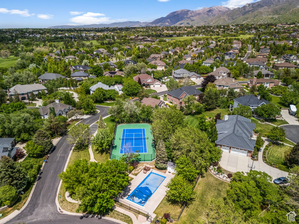 Aerial perspective of suburban area featuring a pool and a mountain backdrop