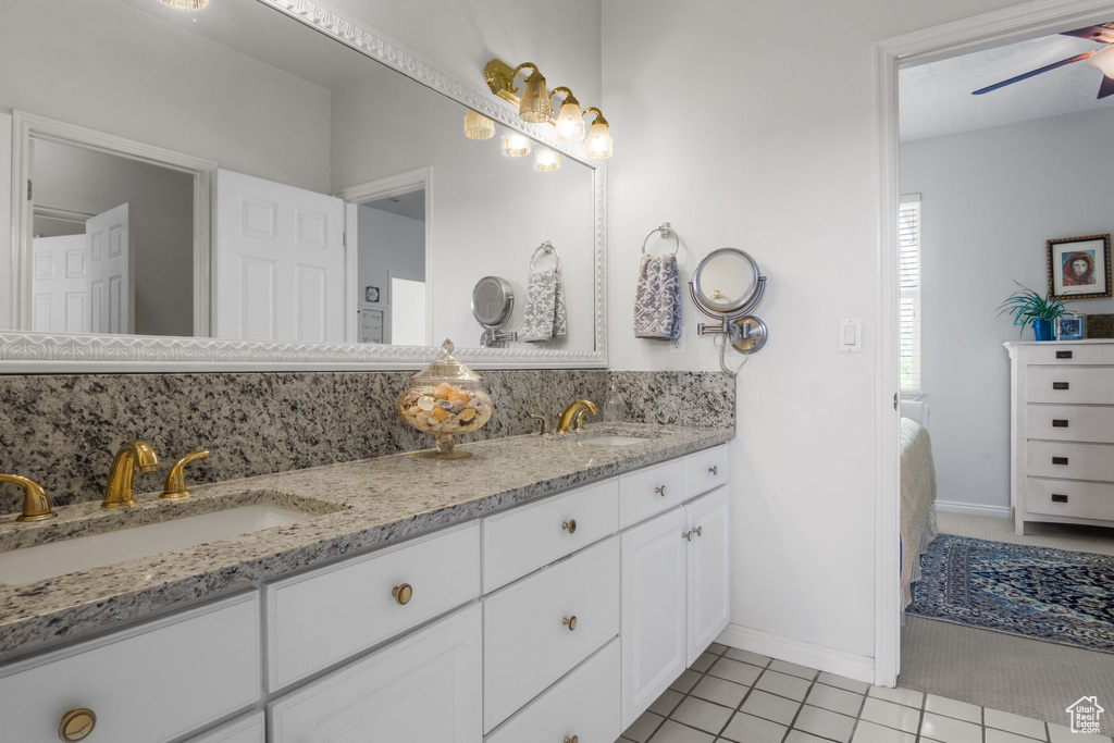 Full bathroom featuring double vanity, tile patterned floors, baseboards, and a ceiling fan
