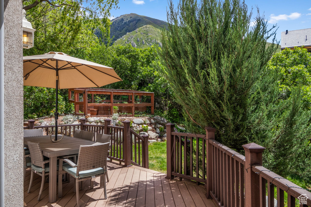 Wooden deck with outdoor dining area and a mountain view
