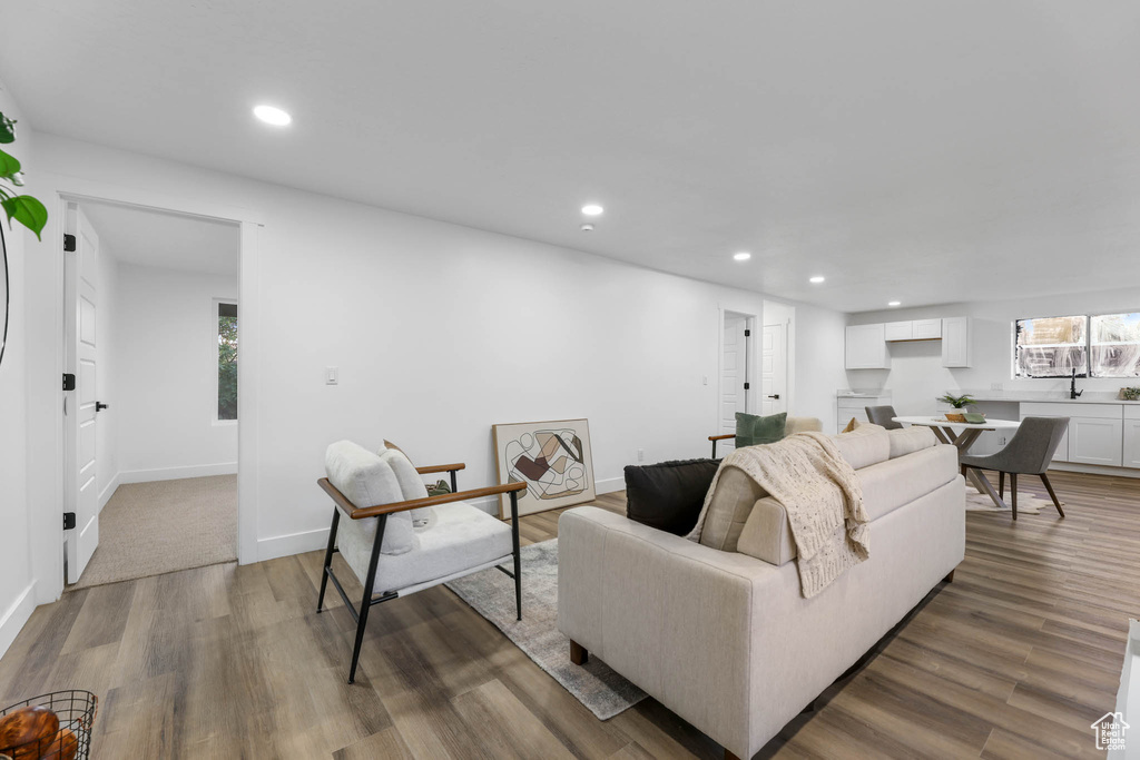 Living room with recessed lighting, wood finished floors, plenty of natural light, and baseboards