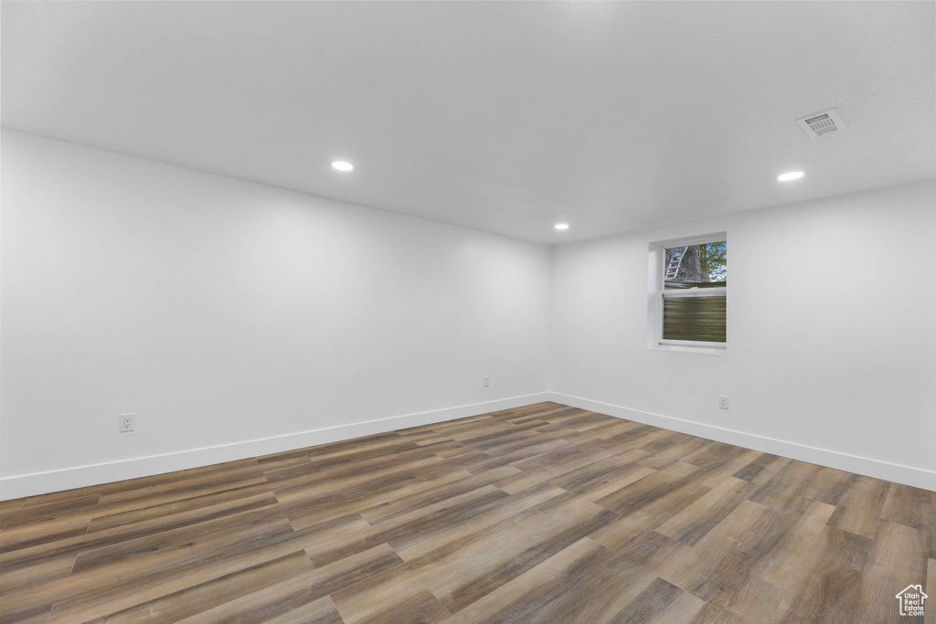 Unfurnished room with wood finished floors, baseboards, and recessed lighting
