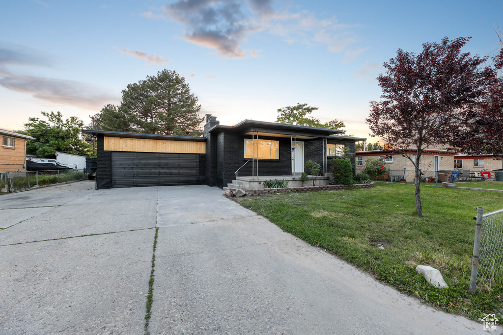 View of front of property with concrete driveway, brick siding, a garage, and a porch