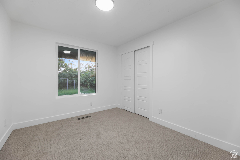 Unfurnished bedroom with baseboards, carpet floors, and a closet