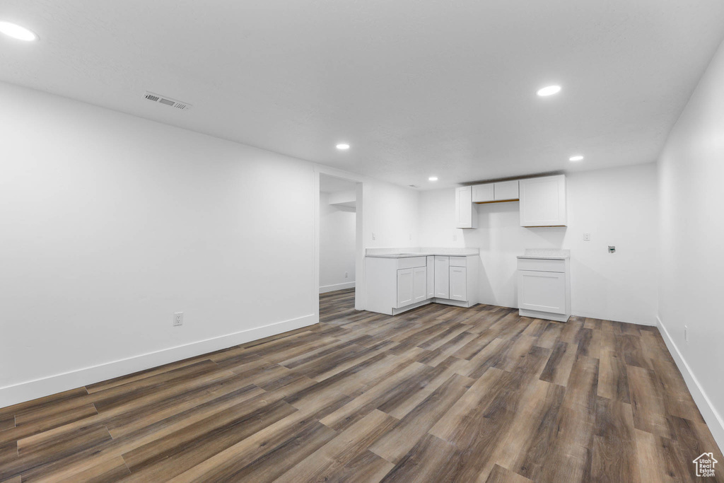 Finished basement with recessed lighting, dark wood-style flooring, and baseboards