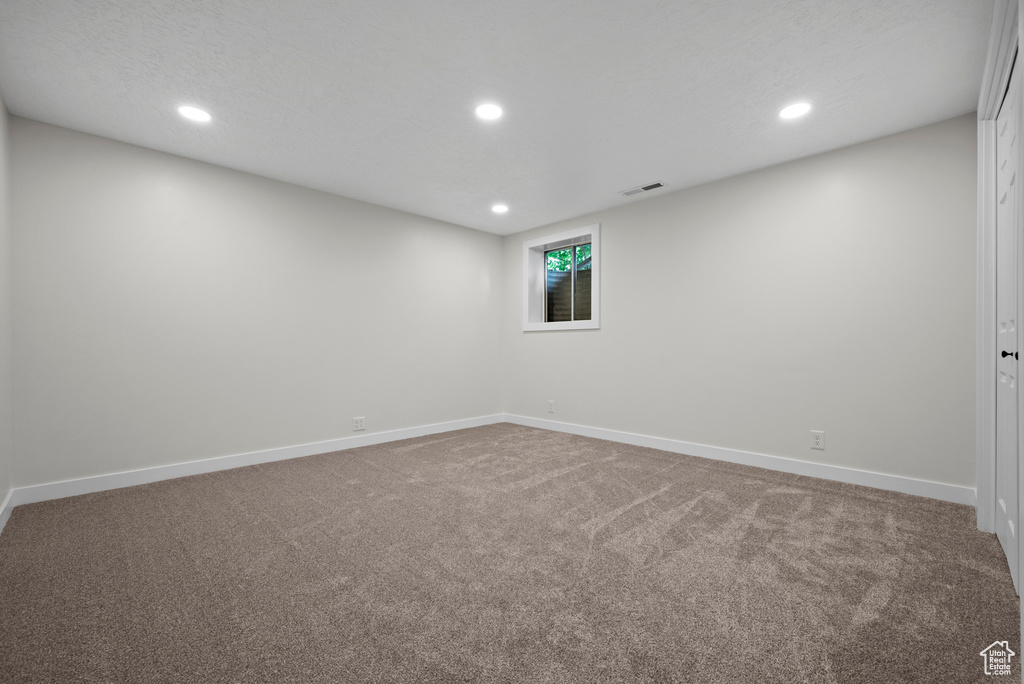 Carpeted empty room featuring recessed lighting and baseboards