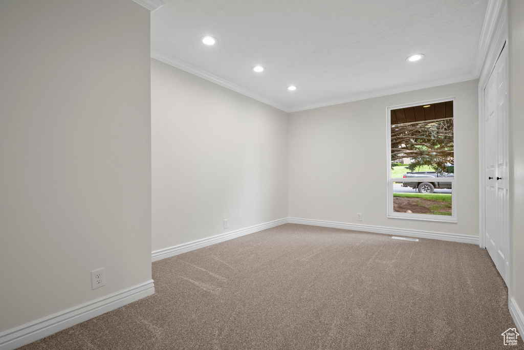 Empty room with crown molding, recessed lighting, carpet, and baseboards