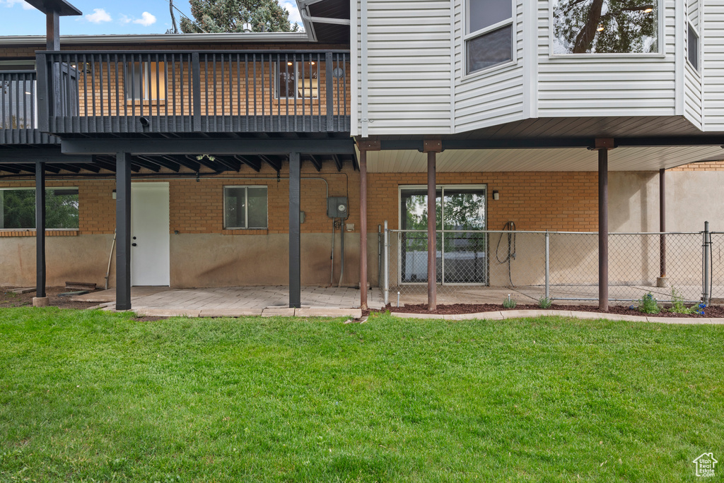 Back of house with brick siding, a patio area, and a deck