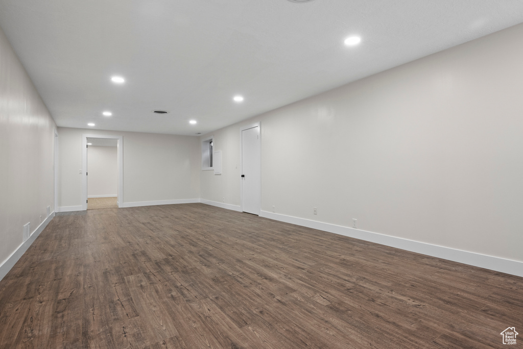 Finished below grade area featuring recessed lighting, dark wood-style floors, and baseboards