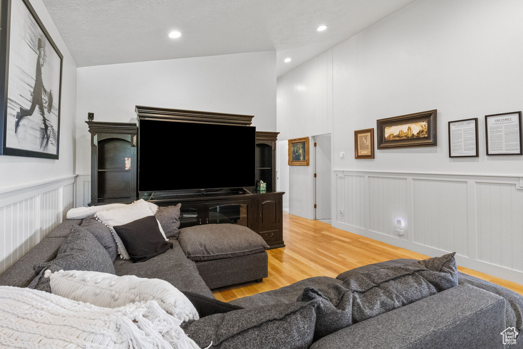 Living area with wood finished floors, wainscoting, a decorative wall, and recessed lighting