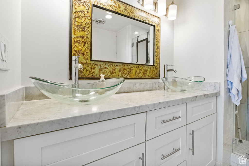 Full bath featuring double vanity and an enclosed shower
