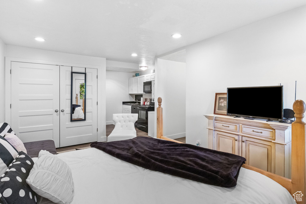 Bedroom with recessed lighting, baseboards, wood finished floors, and a closet