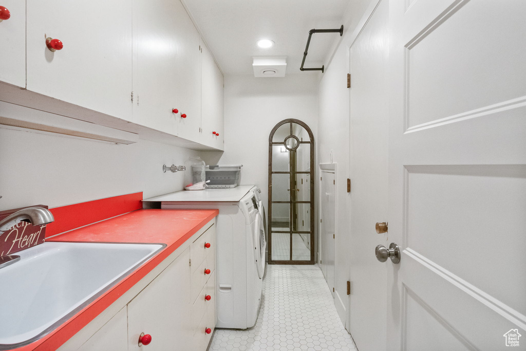 Laundry room featuring cabinet space, separate washer and dryer, and light tile patterned floors