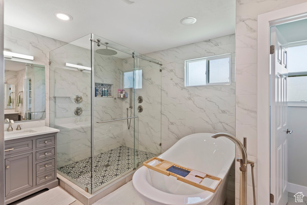 Bathroom with a freestanding tub, a marble finish shower, vanity, and recessed lighting