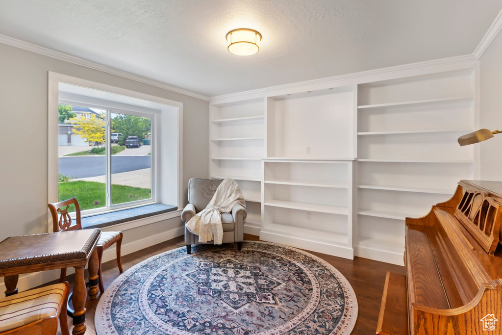 Living area featuring ornamental molding, wood finished floors, and baseboards