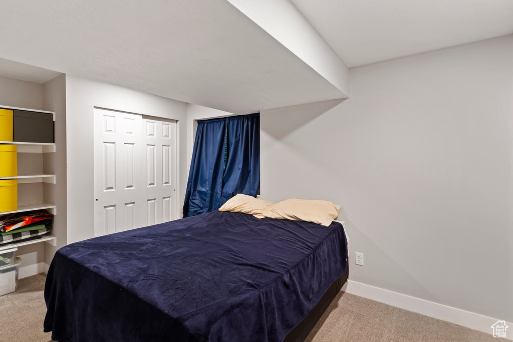 Bedroom with carpet floors, baseboards, and a closet