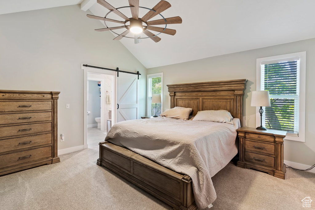Bedroom with a barn door, light colored carpet, baseboards, beamed ceiling, and high vaulted ceiling