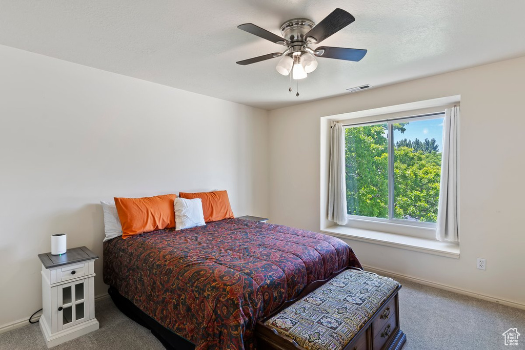 Carpeted bedroom featuring baseboards and ceiling fan