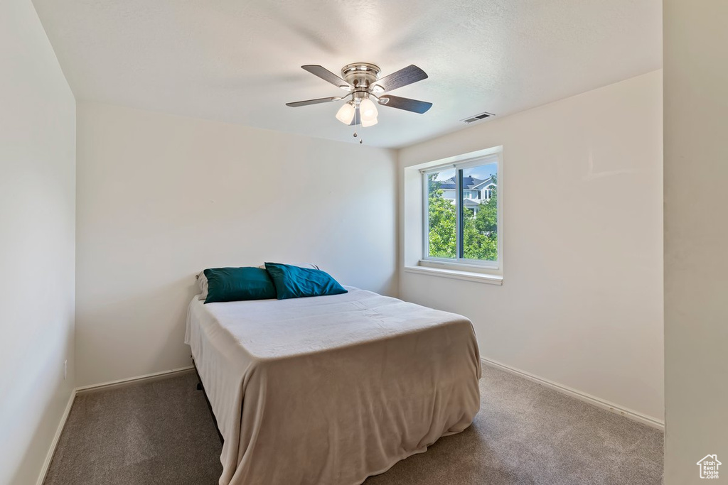 Bedroom with light carpet, baseboards, and a ceiling fan