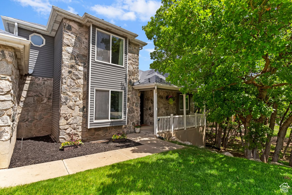 View of front facade featuring stone siding and a front lawn
