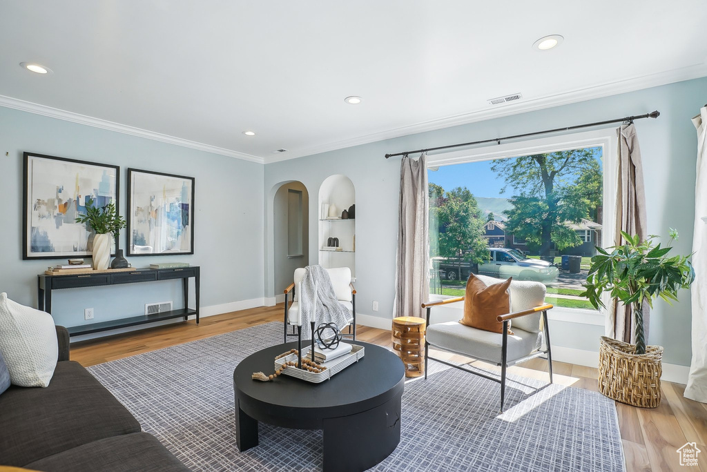 Living room featuring ornamental molding, wood finished floors, baseboards, and recessed lighting