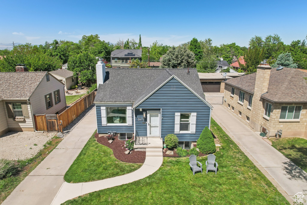 Bungalow-style house featuring a shingled roof, a chimney, and a residential view