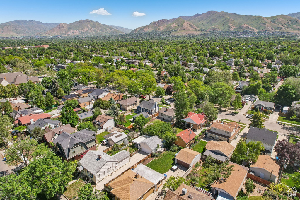 Aerial view of property and surrounding area featuring a mountainous background and nearby suburban area