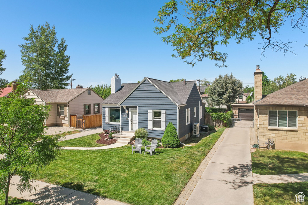 Bungalow-style house with a chimney, a shingled roof, and cooling unit