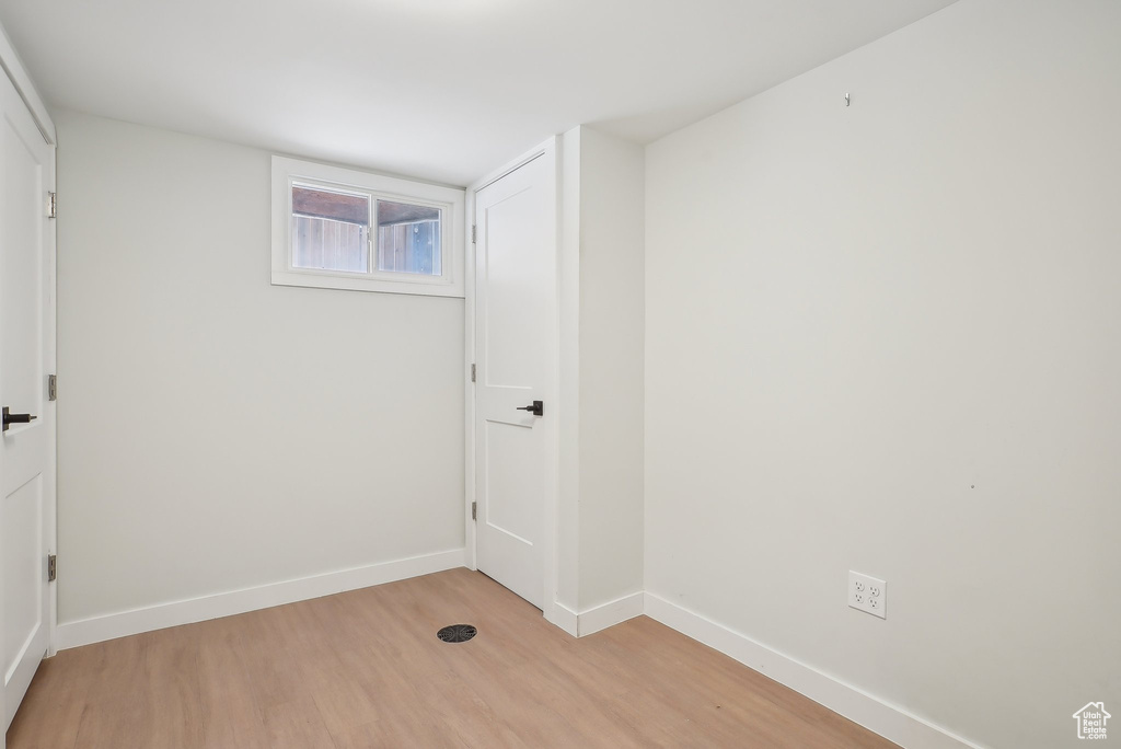 Laundry area featuring light wood-style flooring and baseboards