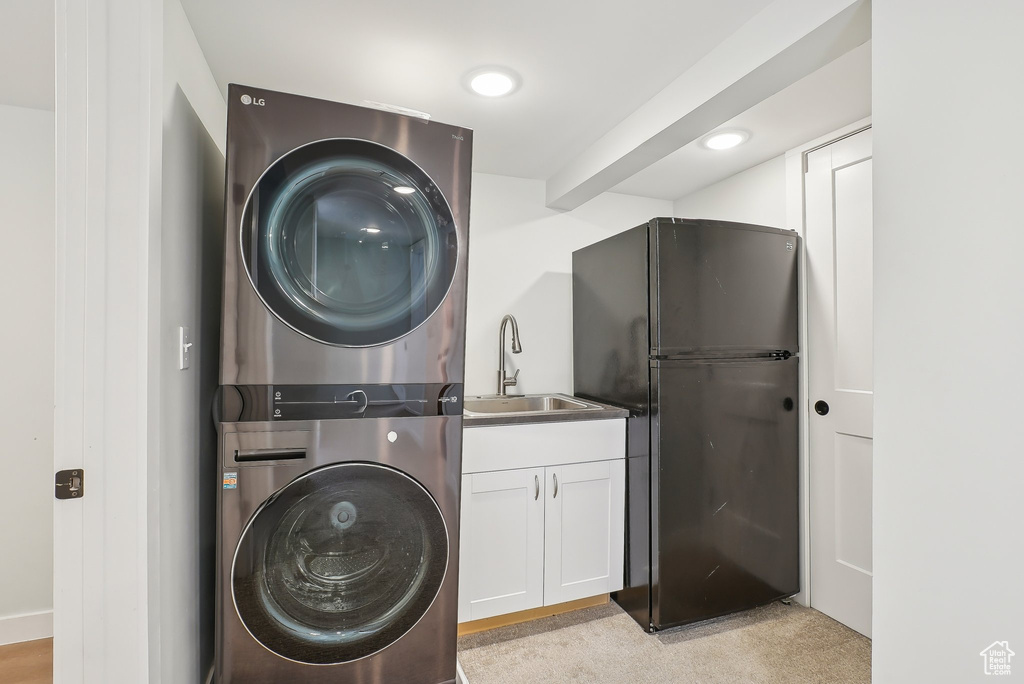 Washroom with stacked washer and clothes dryer, cabinet space, and recessed lighting