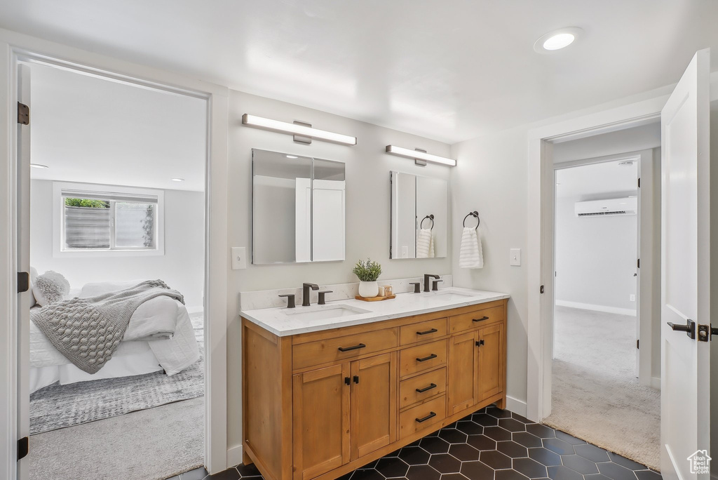 Bathroom with double vanity, an AC wall unit, tile patterned floors, and baseboards