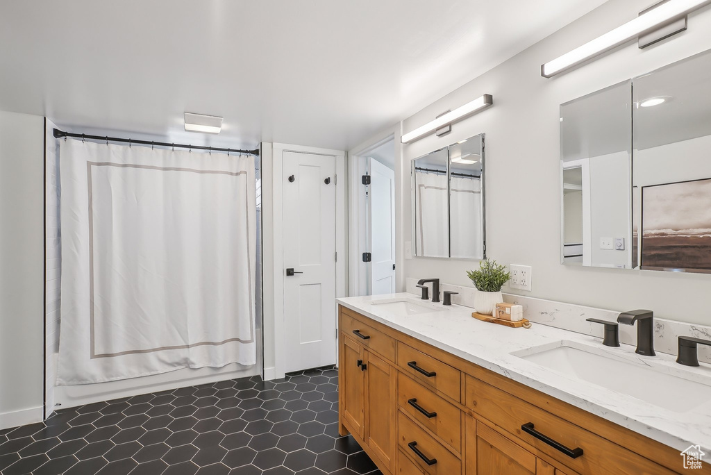 Full bath featuring double vanity and shower / tub combo