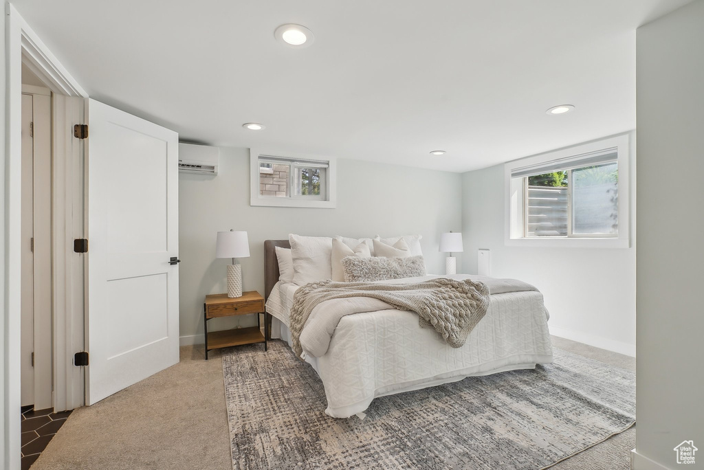 Bedroom with a wall mounted air conditioner, recessed lighting, and baseboards