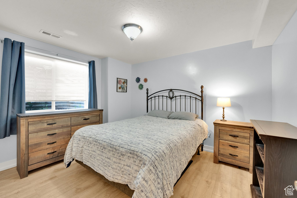 Bedroom with light wood-style floors and baseboards