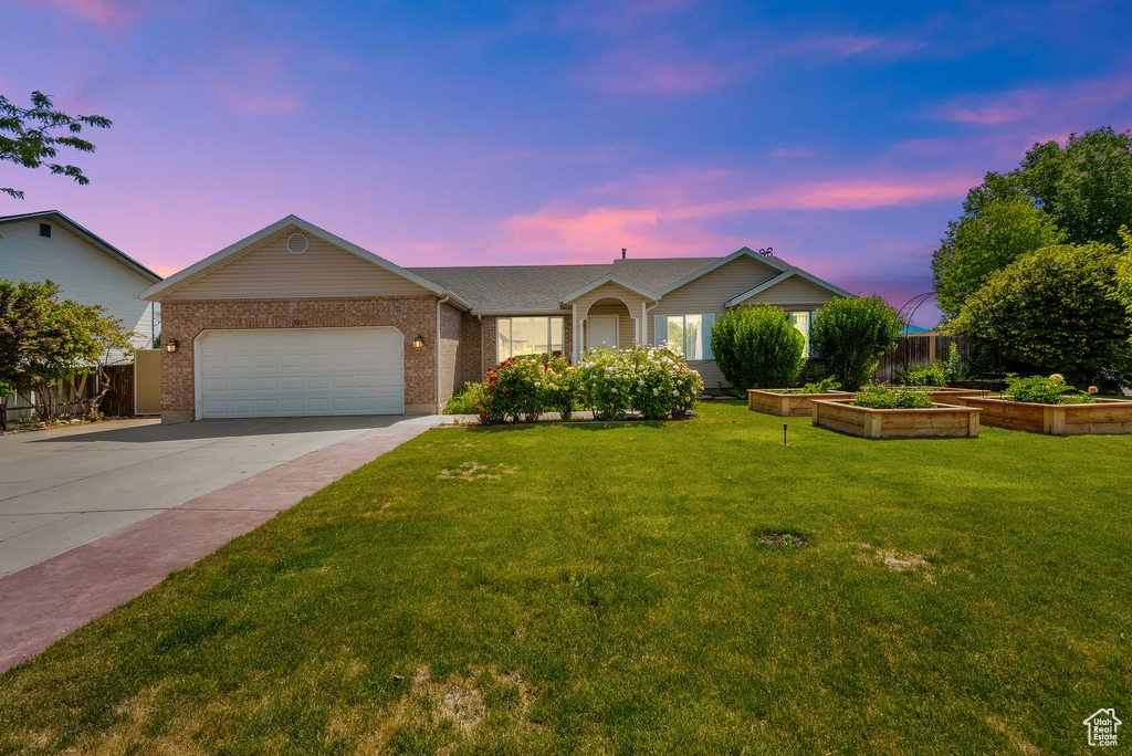 Single story home featuring driveway, brick siding, and a garage