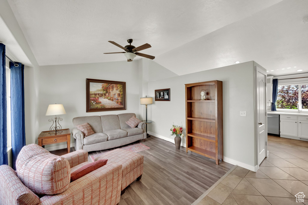 Living room featuring lofted ceiling, a ceiling fan, baseboards, light wood-type flooring, and recessed lighting