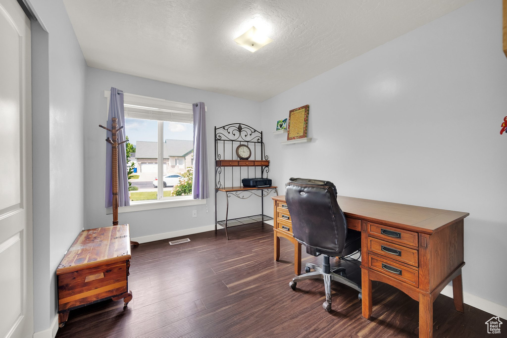 Office space featuring dark wood finished floors and baseboards