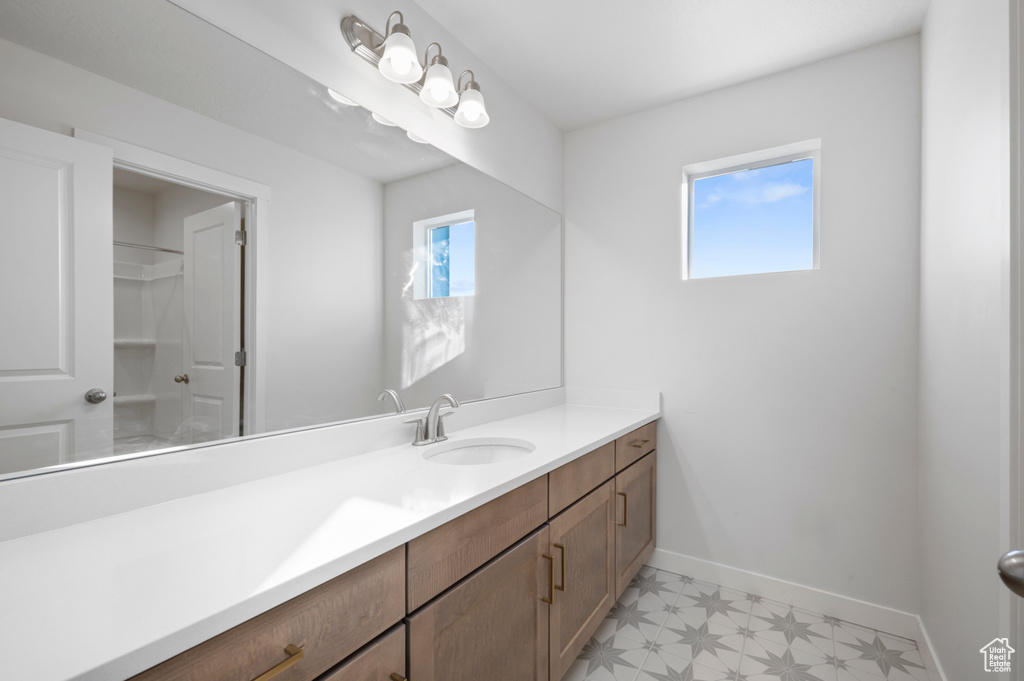 Bathroom featuring vanity, baseboards, and tile patterned floors