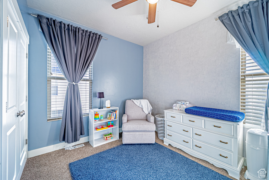 Carpeted bedroom with ceiling fan and baseboards